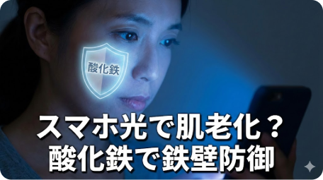 スマホのブルーライトを浴びる女性と、肌を守る酸化鉄の盾。「スマホ光で肌老化？酸化鉄で鉄壁防御」の文字。 TITLE: スマホの光で肌が老化する？酸化鉄で鉄壁防御 FILENAME: bluelight-skin-aging-iron-oxide.png